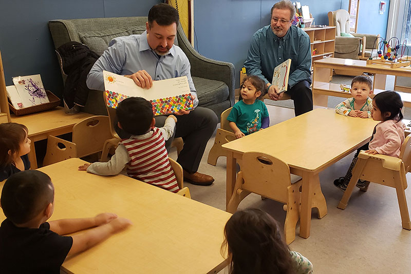 
 colleagues volunteering and reading to children 