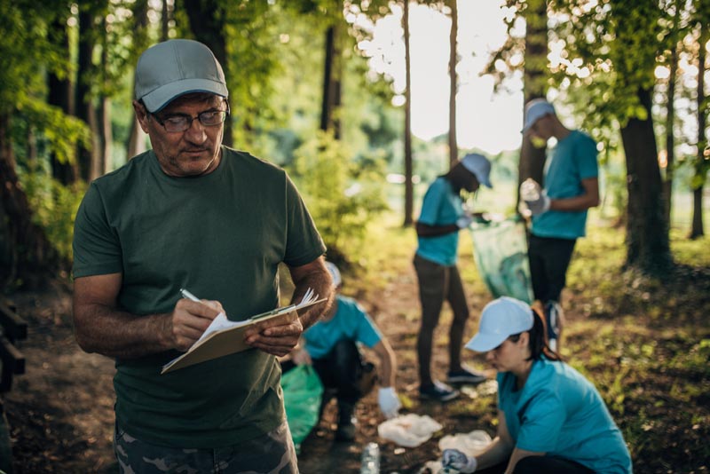 A group of volunteers works to restore an outdoor trail and utilize Government and Non-profit banking services