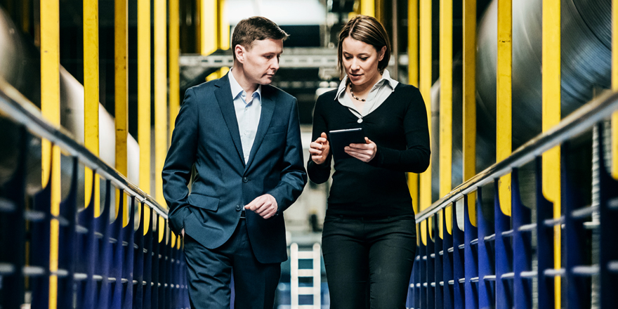 A businessman looks at his phone and laptop and manages his business finances with Liquidity Management tools